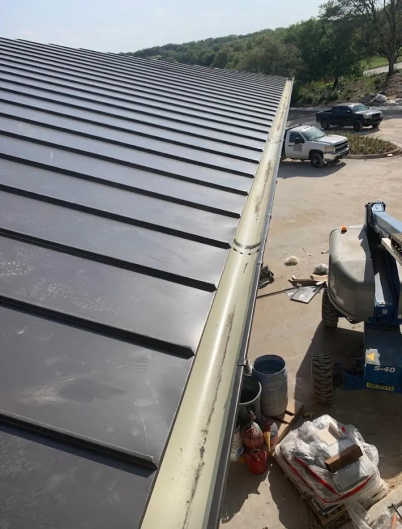 Standing seam panel and gutter detail on a metal roofing jobsite in Roswell